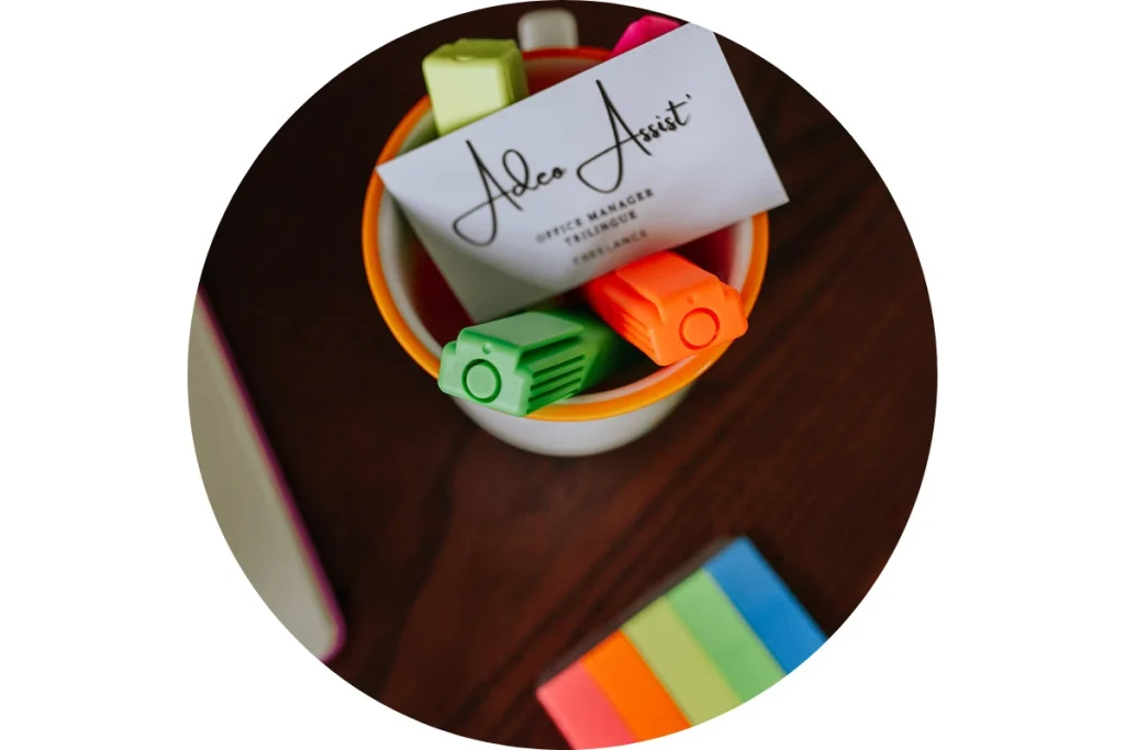 Photo d’un pot à fournitures de bureau avec Stylos, Post-it et carte de visite du Responsable administratif.